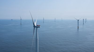 Bilde av flere havvindmøller til havs på en solrik dag.